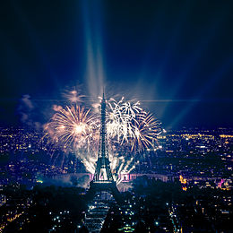 fireworks going off behind the Eiffel tower at night